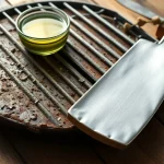 Vergleich eines schmutzigen und eines gereinigten Grillrostes mit Reinigungsutensilien